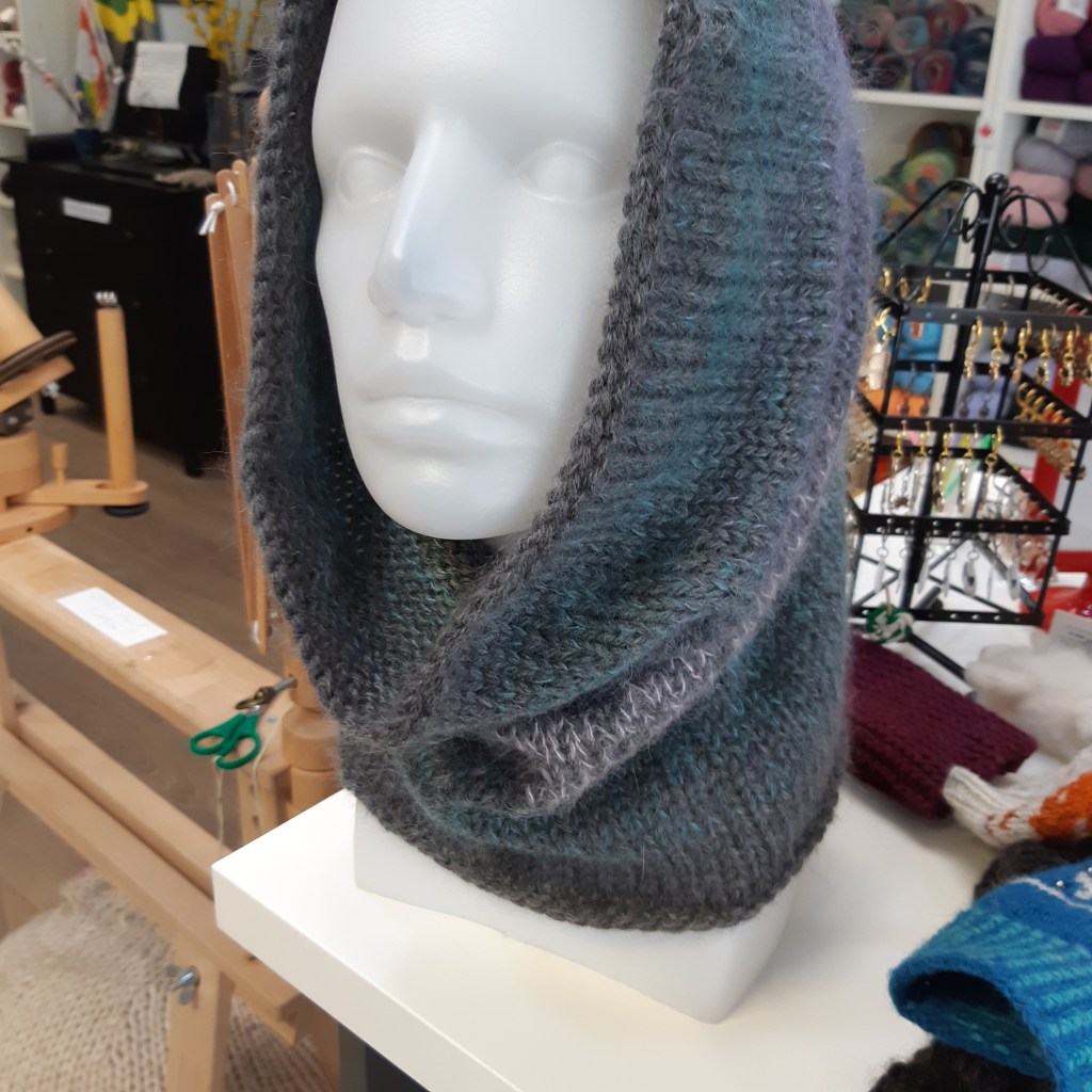 grey mohair and wool cowl pulled up onto the top of the head of a plastic head manequin